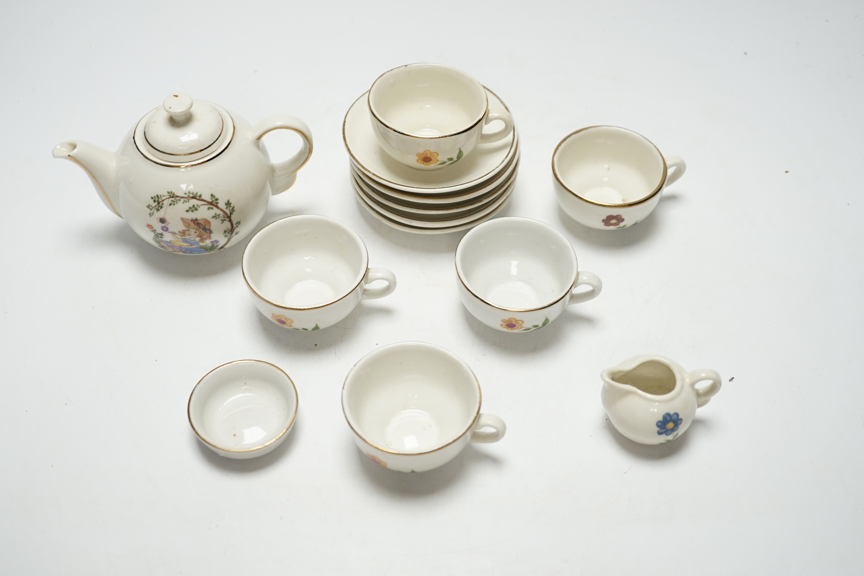 A child’s tea set comprising a teapot, five cups and saucers and a milk jug, teapot 8.5cm